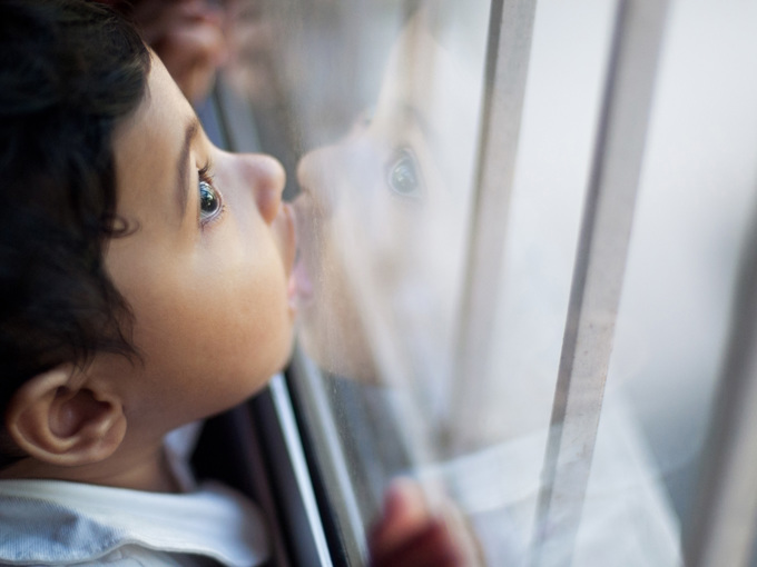 Cute Baby Girl Kissing Glass Window Pane